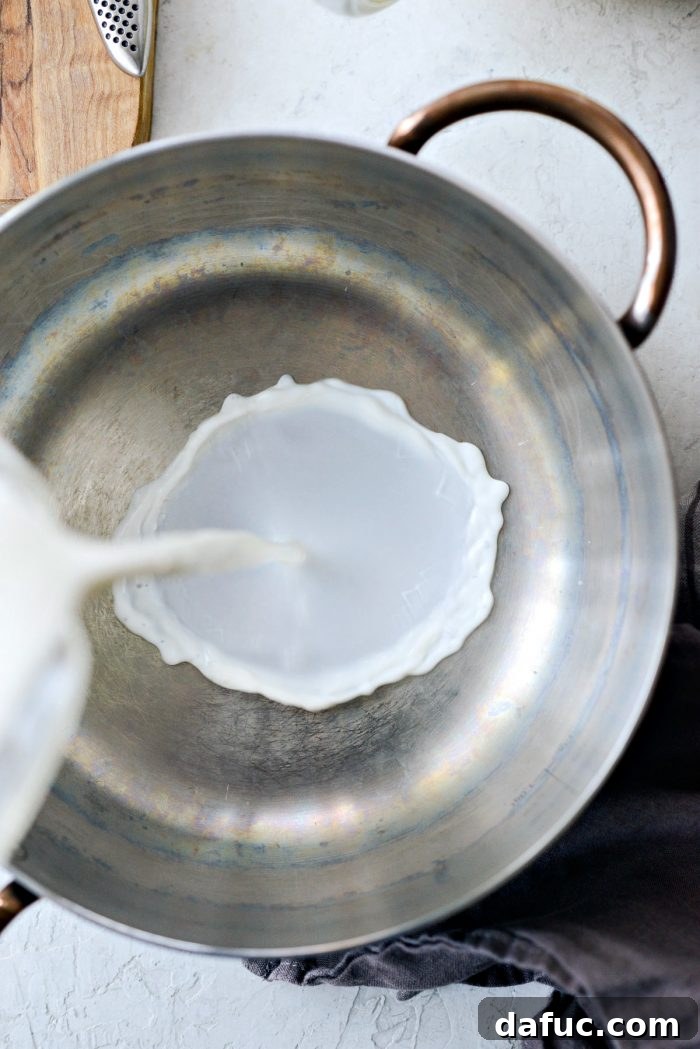 Velvet Vanilla Gelato 8 Pouring 2 cups of whole milk into a saucepan for heating.