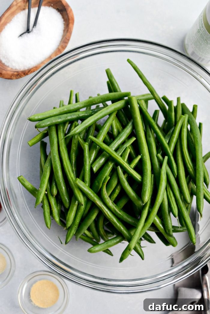 Crispy Air Fryer Green Beans 5 Trimmed fresh green beans in a clear glass bowl, ready for seasoning