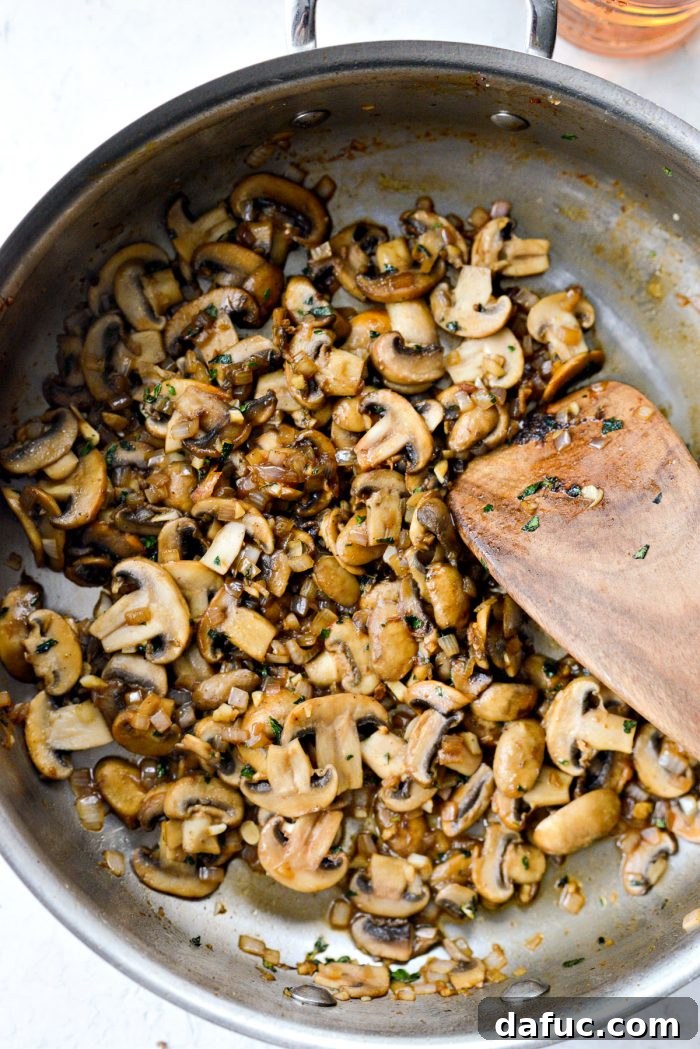 Mushrooms, shallots, garlic, and herbs sautéing gently in the skillet until tender and lightly browned.