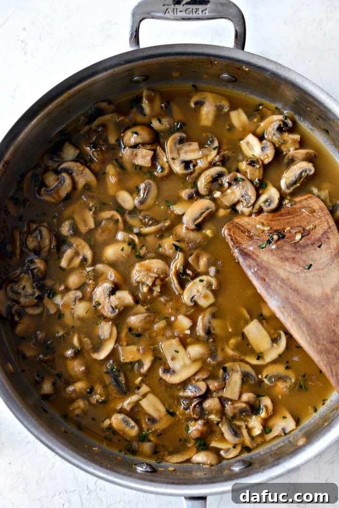 The mushroom and Marsala wine sauce simmering and visibly thickening in the skillet.