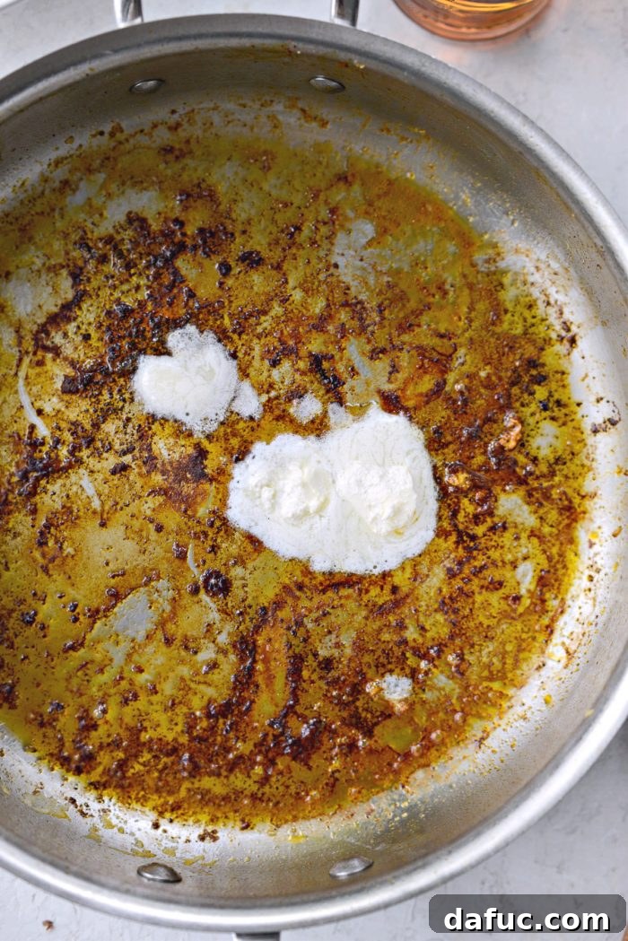 Additional whipped butter and extra light olive oil being added to the same skillet after the chicken has been removed.