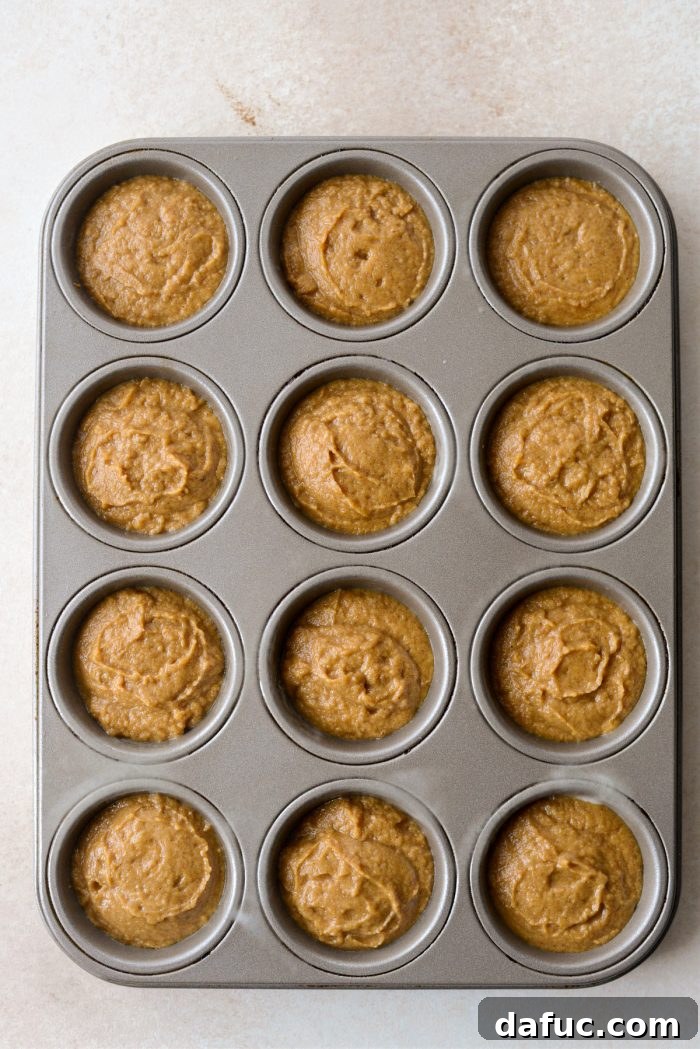 Muffin pan tapped on counter to settle batter