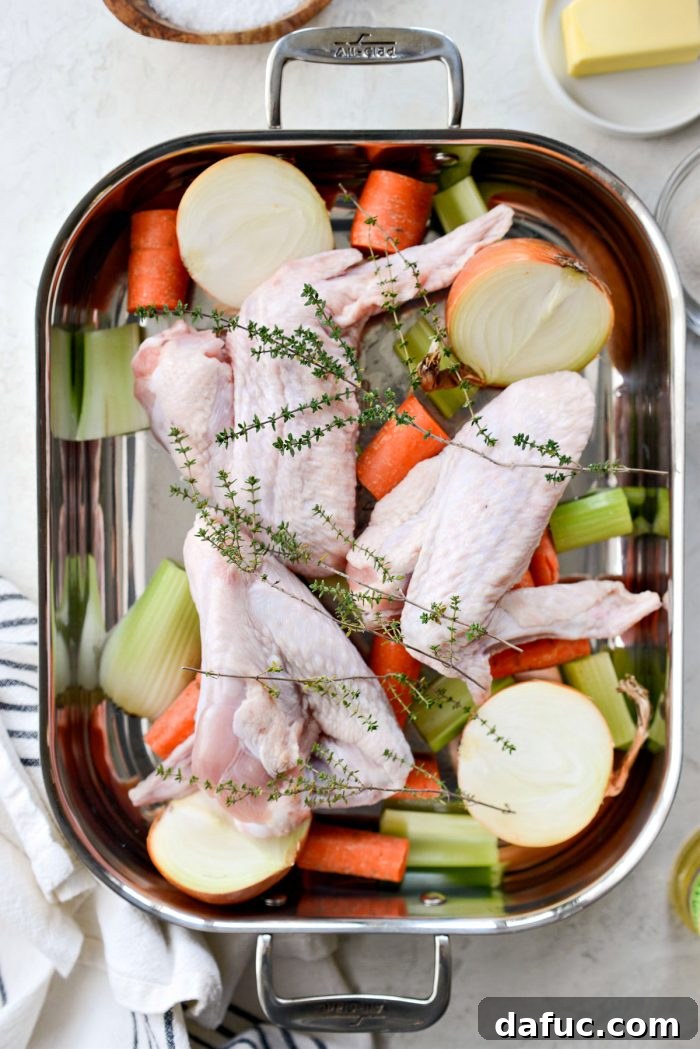Delicious Gravy, Made in Advance 6 roasting pan with vegetables, herbs and turkey wings - Prepped ingredients in a roasting pan