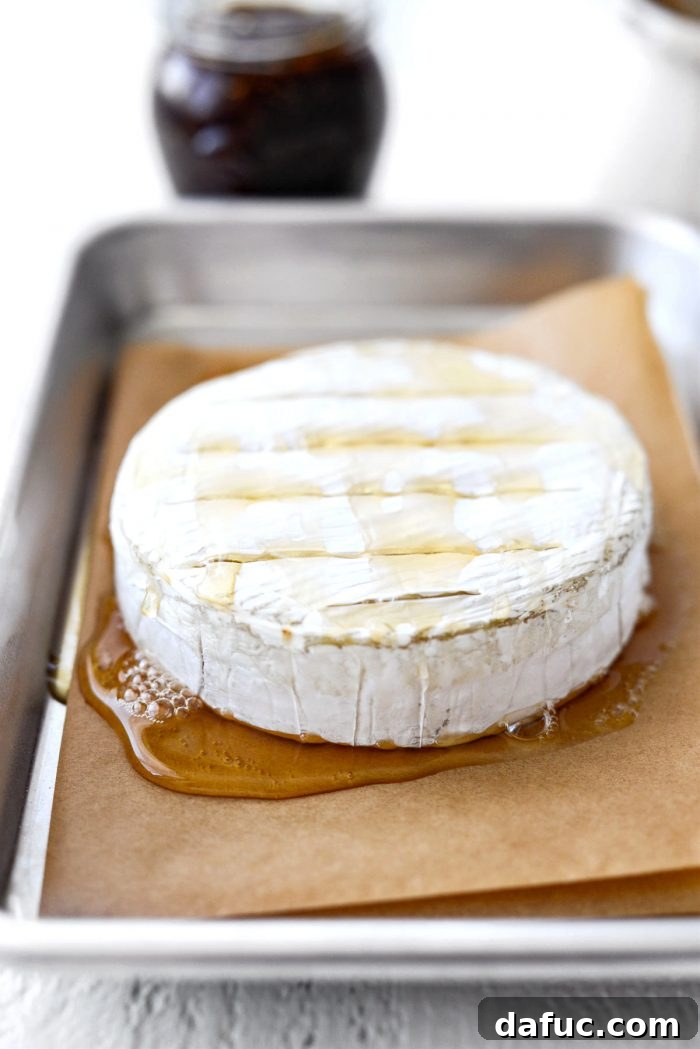 Honey baked brie cheese in the oven, melting to perfection.