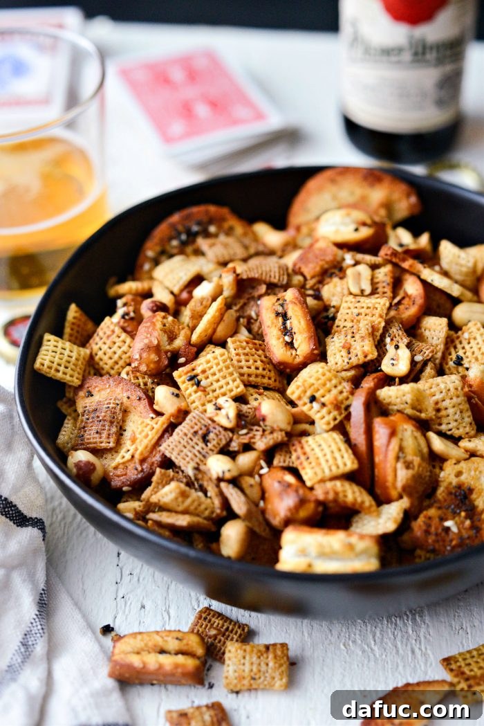 The Ultimate Everything Bagel Chex Mix 3 Overhead view of a large bowl of Everything Plus the Bagel Chex Mix, featuring a generous mix of cereals, pretzel nuggets, bagel chips, and roasted peanuts, ready to be coated.