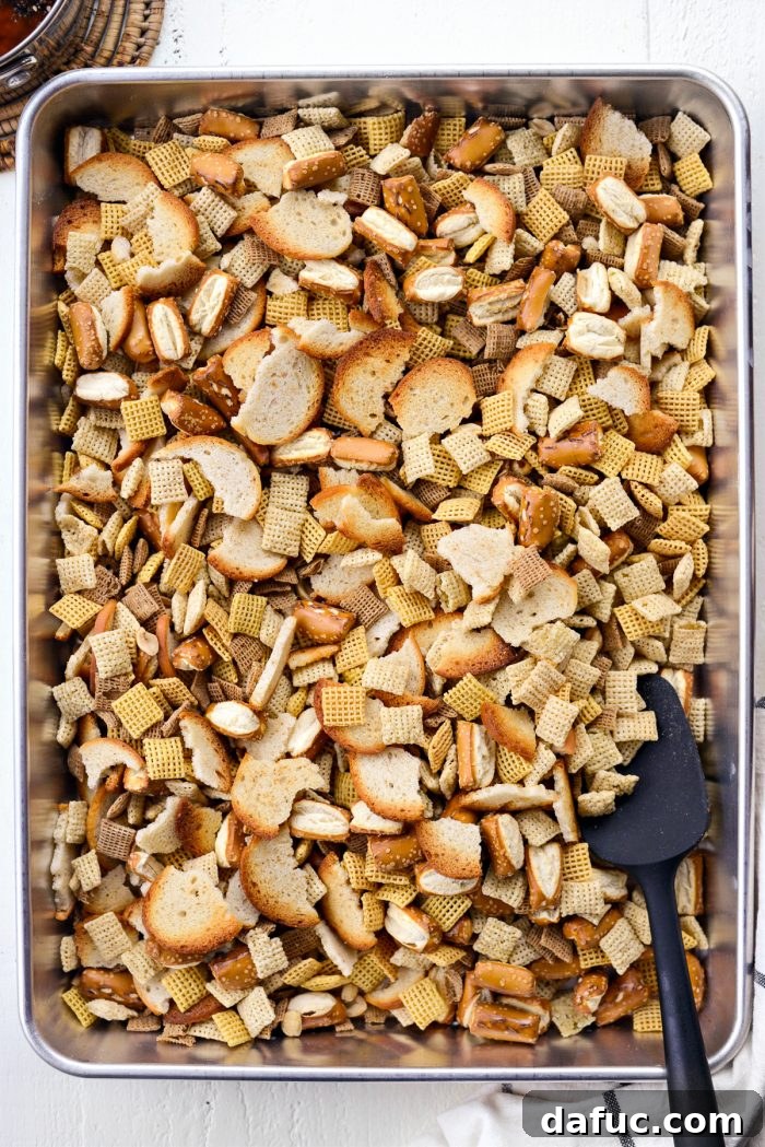 The Ultimate Everything Bagel Chex Mix 7 All dry ingredients for the Chex Mix, including cereals, bagel chips, pretzels, and peanuts, are thoroughly mixed together in a deep-sided roasting pan before the butter mixture is added.