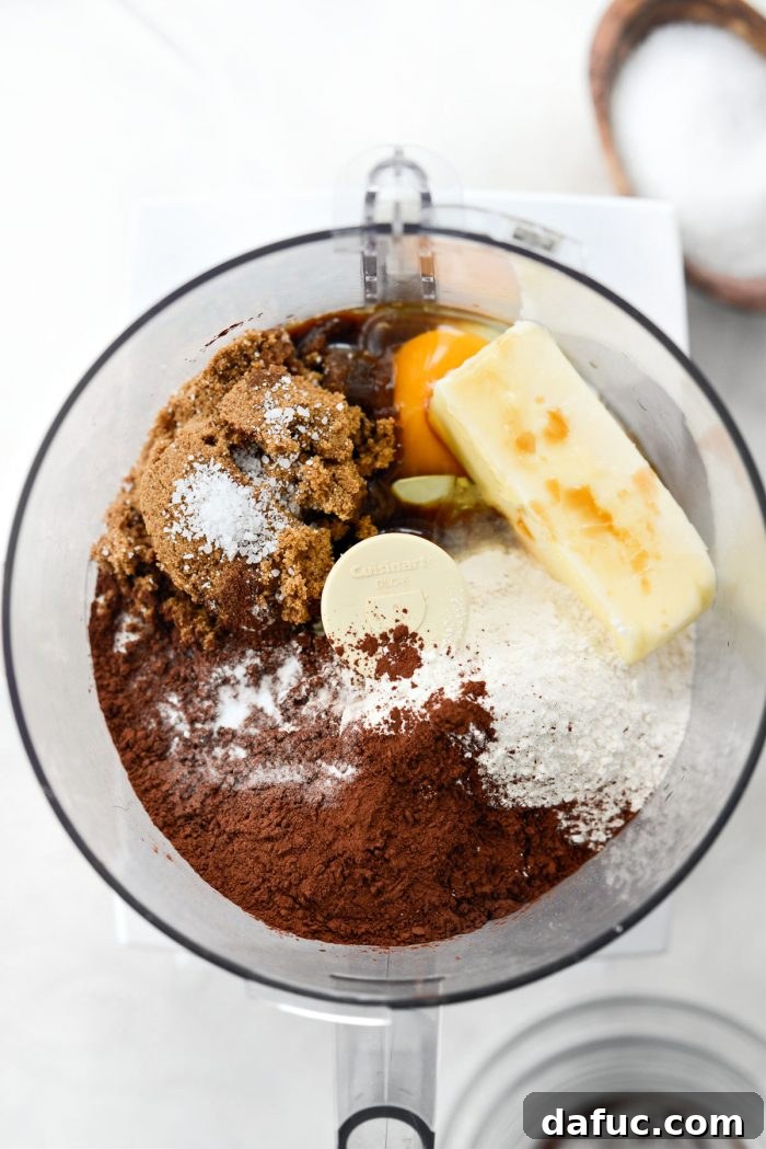 Dry and wet ingredients being added to a food processor