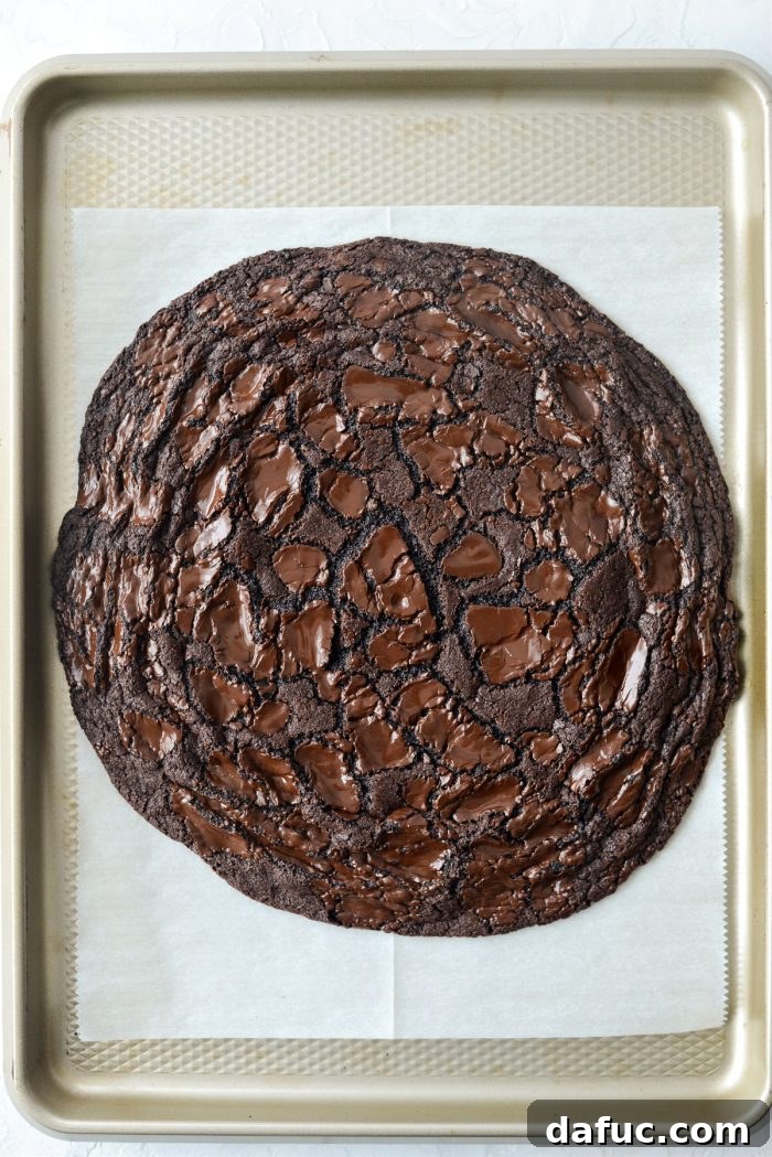 Freshly baked Double Dark Chocolate Share Cookie, still on parchment paper