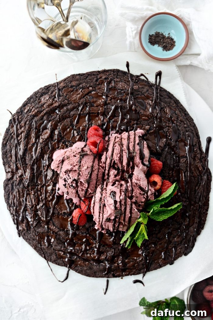 Double Dark Chocolate Share Cookie with ice cream and chocolate syrup on a serving plate