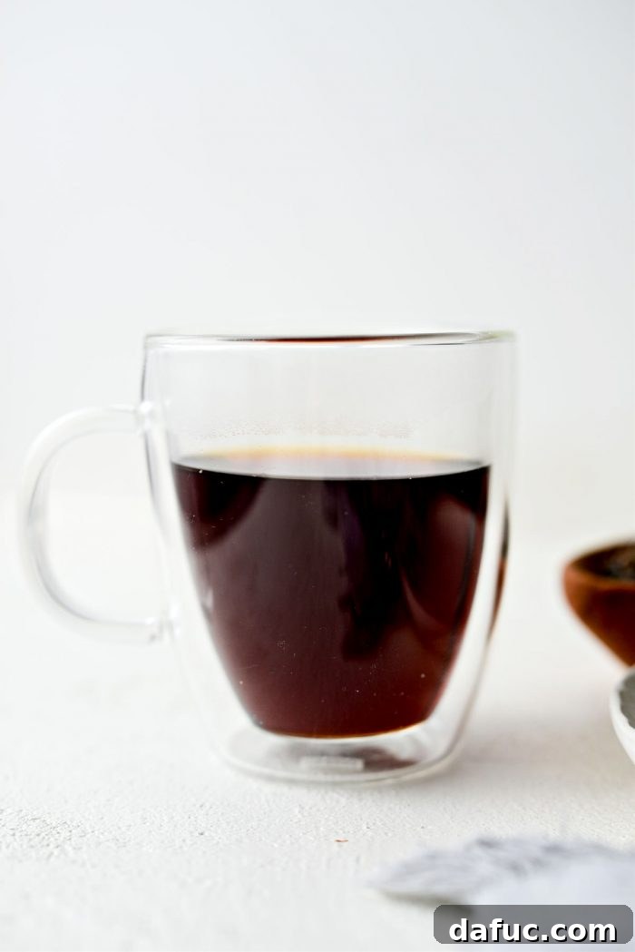 Pouring the brewed Earl Grey tea into a large mug.