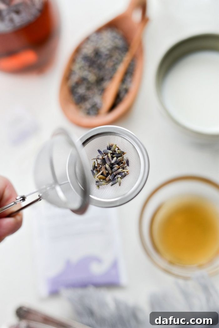 A small tea infuser filled with dried culinary lavender, ready to be steeped in hot water.
