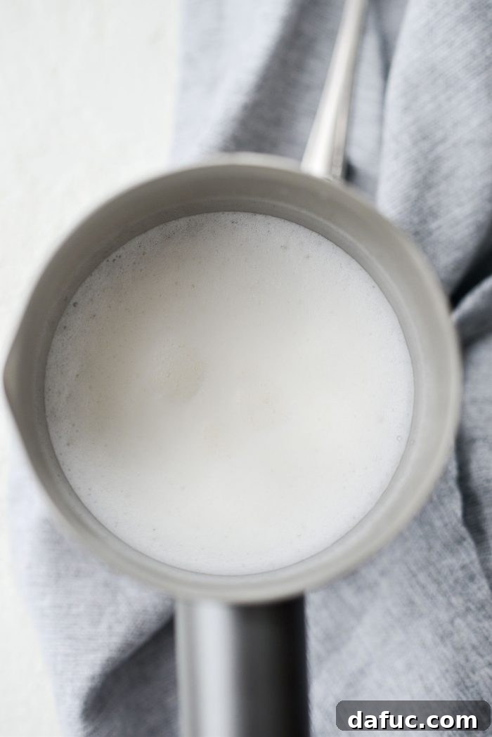 Perfectly frothed milk in a frother, showing its creamy and airy texture.