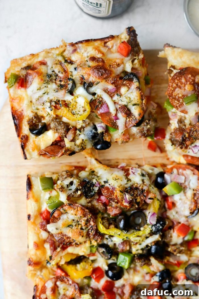 Ultimate Focaccia Pizza 3 A perfectly sliced corner piece of Focaccia Pizza Supreme, revealing its deep-dish layers.
