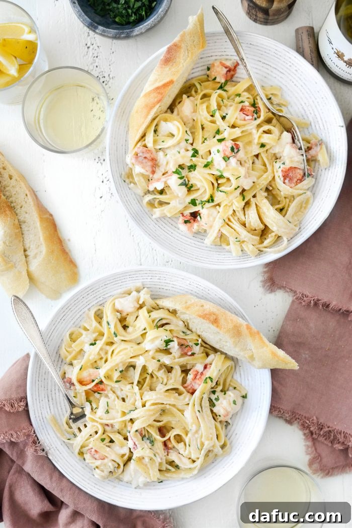 two bowls of Garlicky Lobster Fettuccine Alfredo with bread.