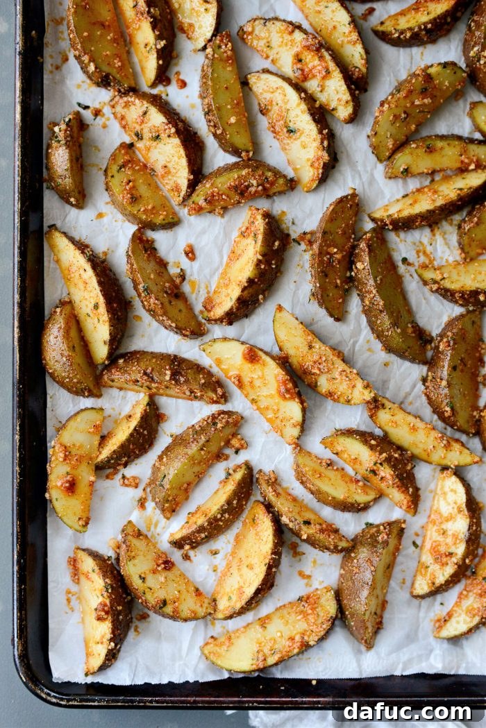 Arranging Seasoned Potato Wedges in a Single Layer on a Parchment-Lined Baking Sheet