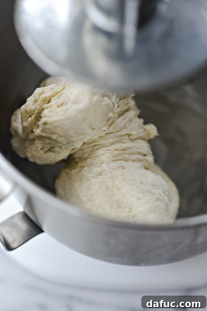 Bite-Sized Pita Pockets 11 Stand mixer actively kneading pita dough with a dough hook for 6 minutes
