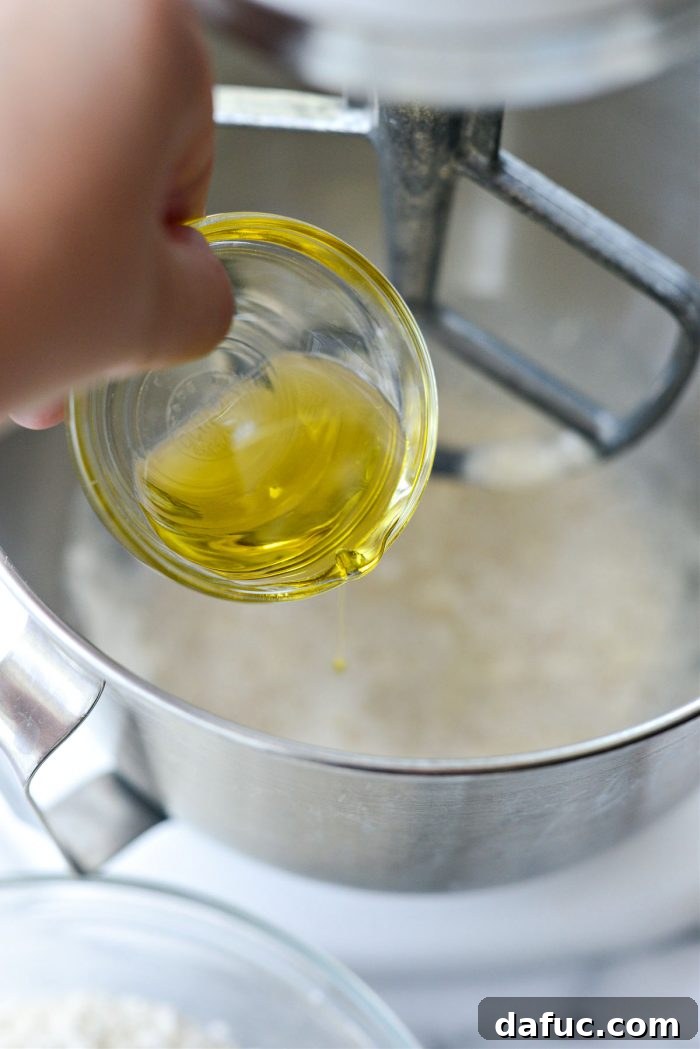 Bite-Sized Pita Pockets 8 Adding olive oil to the developing pita dough in a mixing bowl