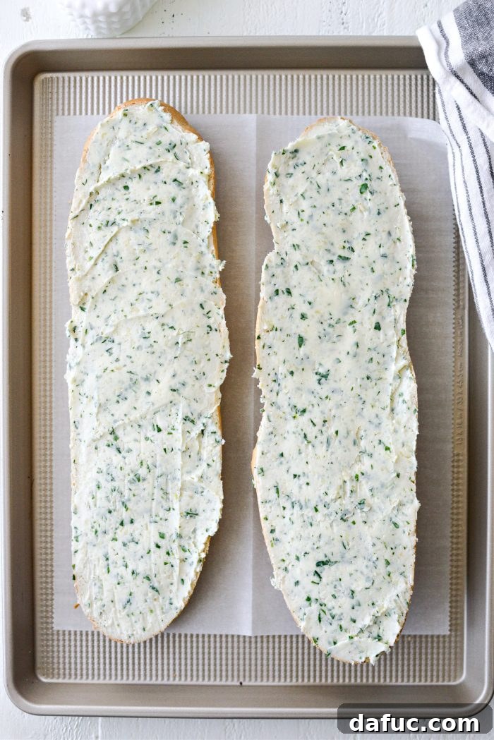 Both halves of buttered bread on a baking sheet, glistening and ready to be baked to golden perfection