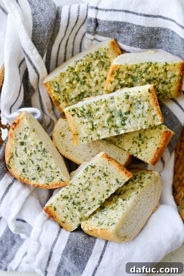 A single slice of warm, perfectly baked 15-Minute Garlic Bread with melted butter and visible herbs