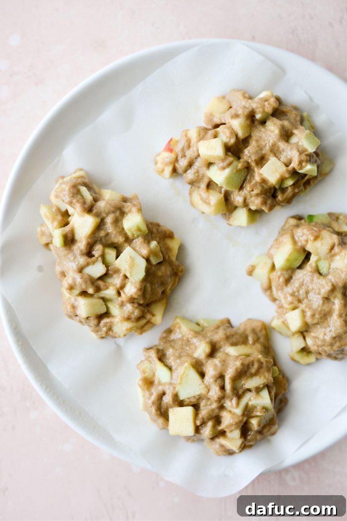 Guilt-Free Air Fryer Apple Fritters 12 Four mounds of apple fritter batter on air fryer parchment paper