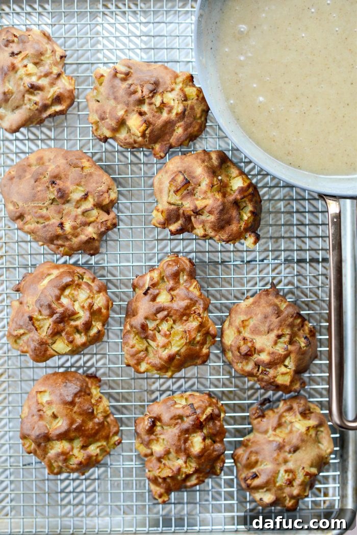 Guilt-Free Air Fryer Apple Fritters 15 Cooked apple fritters resting on a wire rack over a rimmed baking sheet