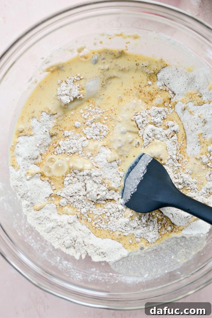 Guilt-Free Air Fryer Apple Fritters 8 Wet ingredients being poured into dry ingredients