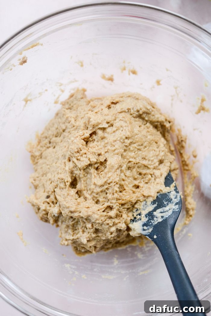 Guilt-Free Air Fryer Apple Fritters 9 Mixture being gently combined with a spatula
