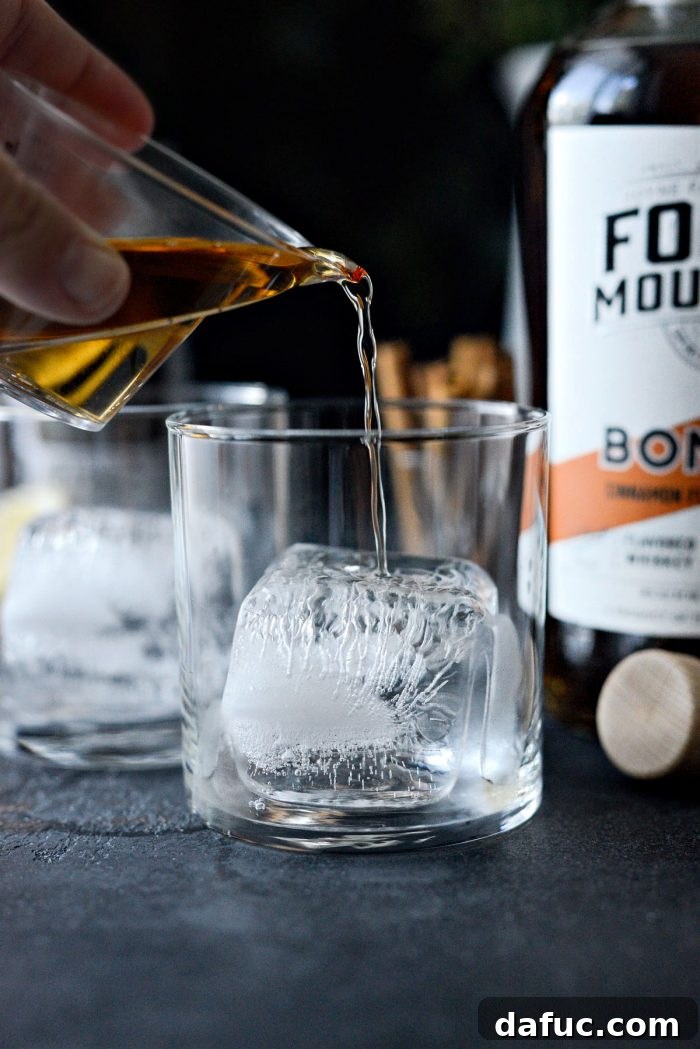 Autumn Ember Cider 7 Pouring cinnamon whiskey over ice for Bonfire Cider