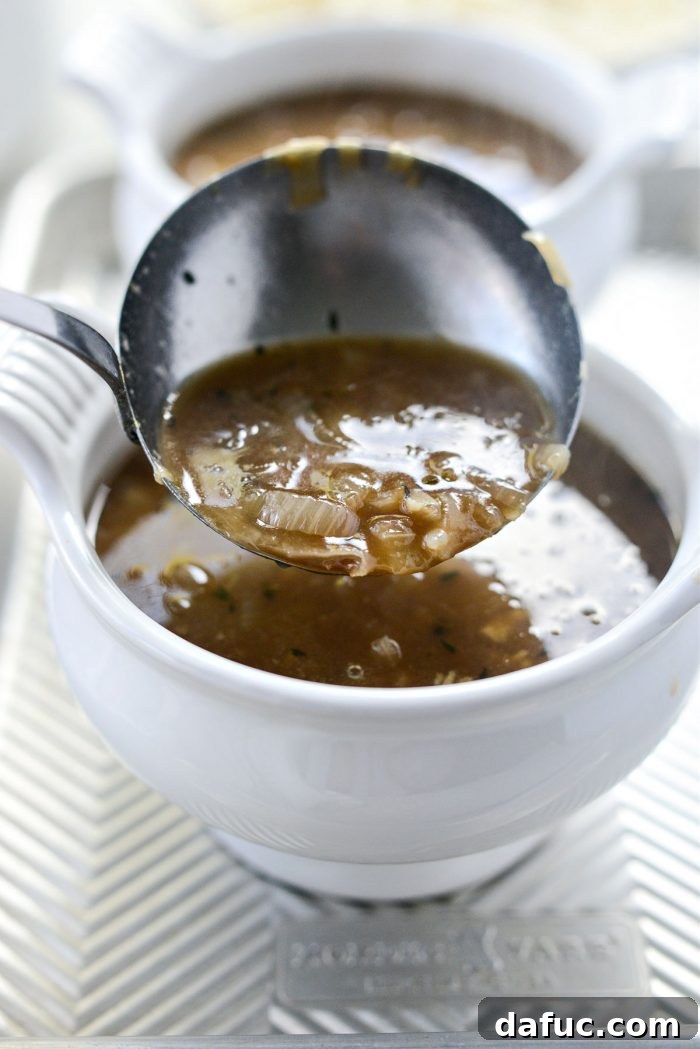 Ladling Smoky Beer French Onion Soup into individual oven-safe bowls.