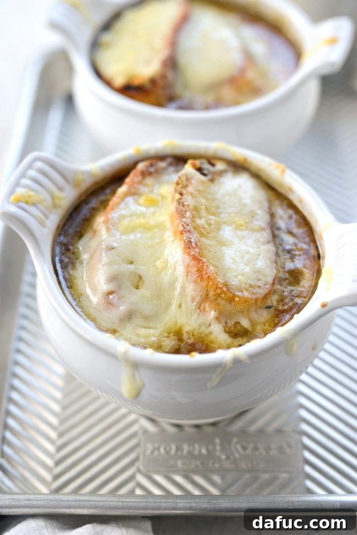 Smoky Beer French Onion Soup broiling in the oven until the cheese is melted and bubbly golden brown.