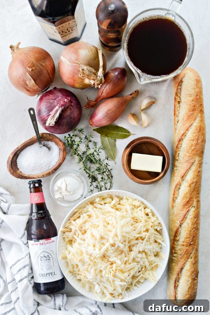 Ingredients laid out for Smoky Beer French Onion Soup: onions, butter, garlic, thyme, beer, beef stock, baguette, and Gruyère.