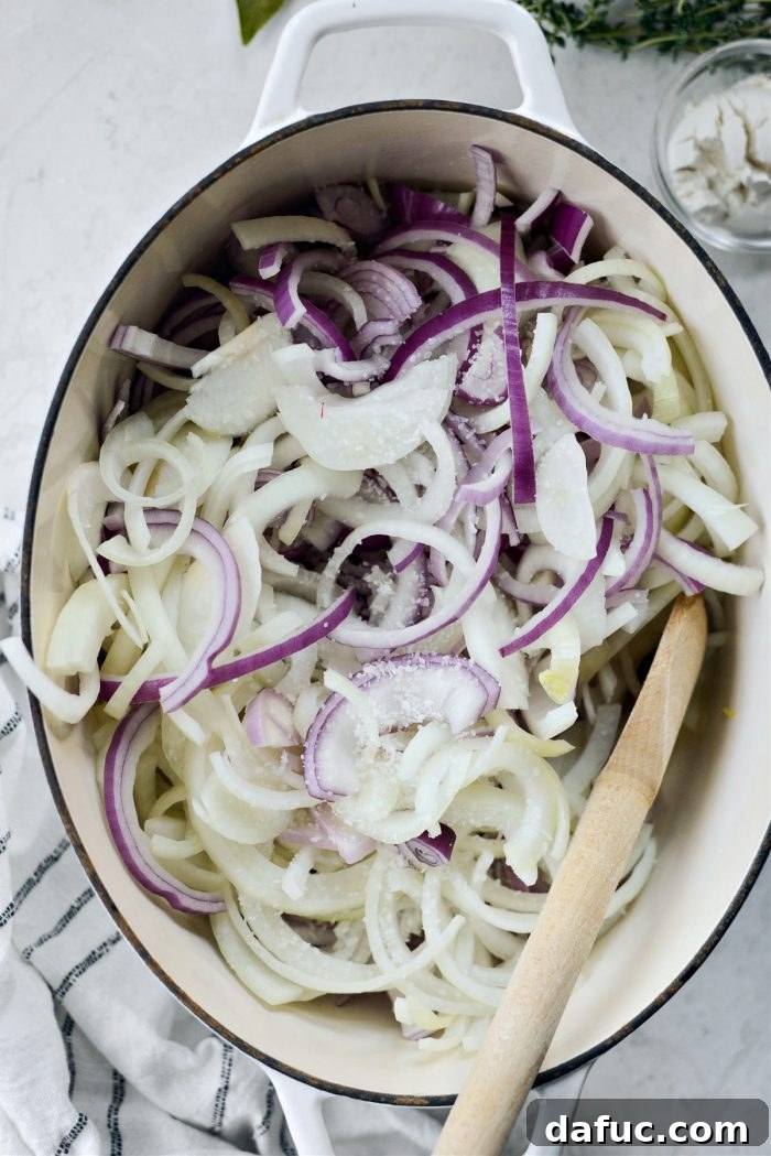 Sliced onions and kosher salt added to the melted butter in a Dutch oven.