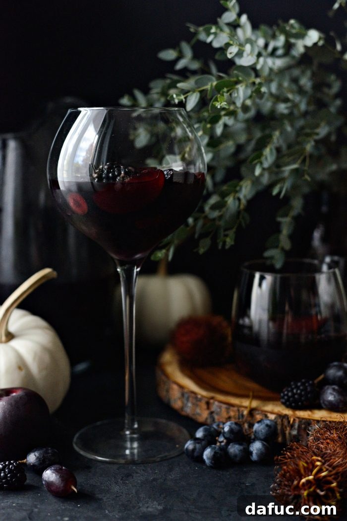 Black Magic Sangria presented in a glass pitcher with dark fruits