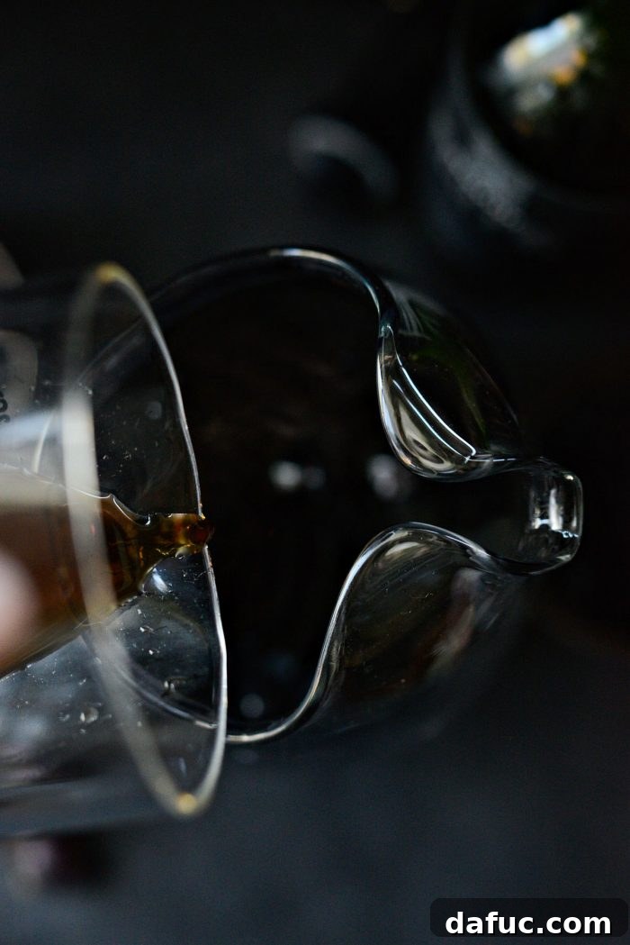 Adding simple syrup, juice, and vanilla brandy to sangria mixture