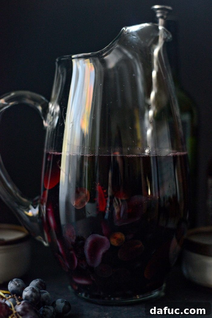 Stirring the Black Magic Sangria in a pitcher