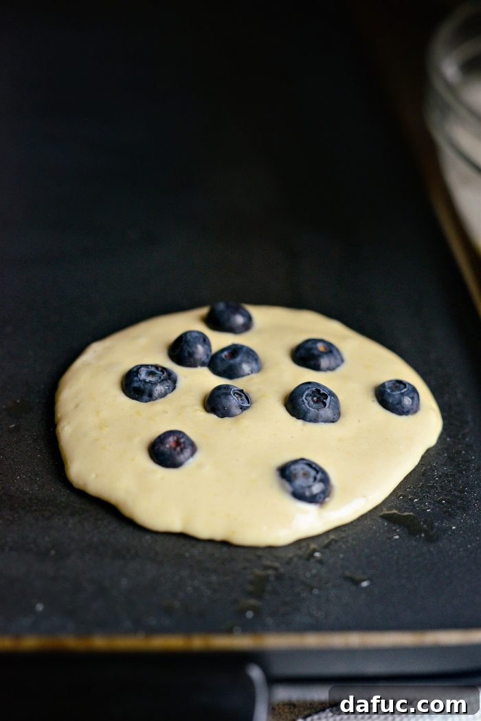 Bright Lemon Blueberry Pancakes 13 drop in blueberries onto cooking pancakes