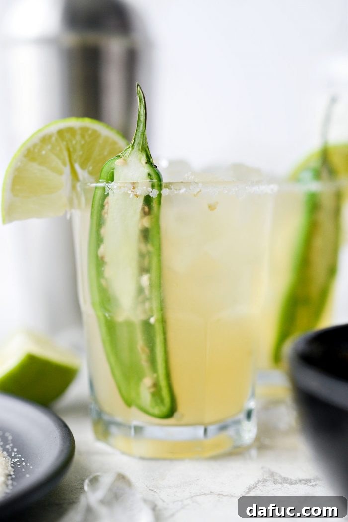 The Story of 2021 11 Two glasses of vibrant Spicy Jalapeno Margaritas with lime wedges