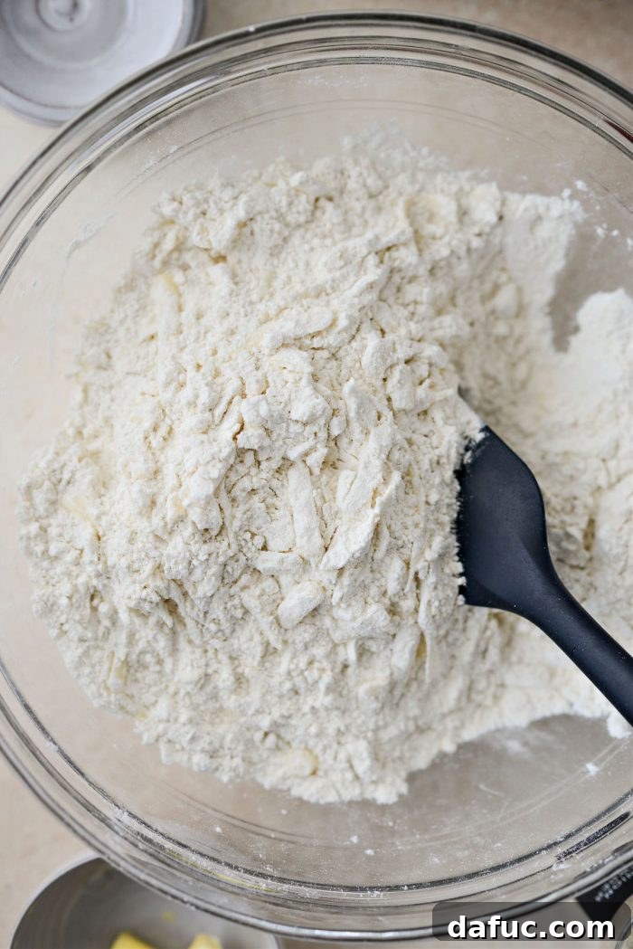Stirring cheese into dry ingredients and making a well
