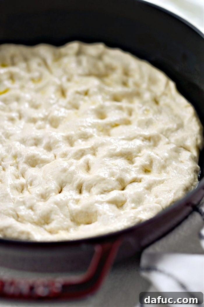 Stretching focaccia dough in the pan.