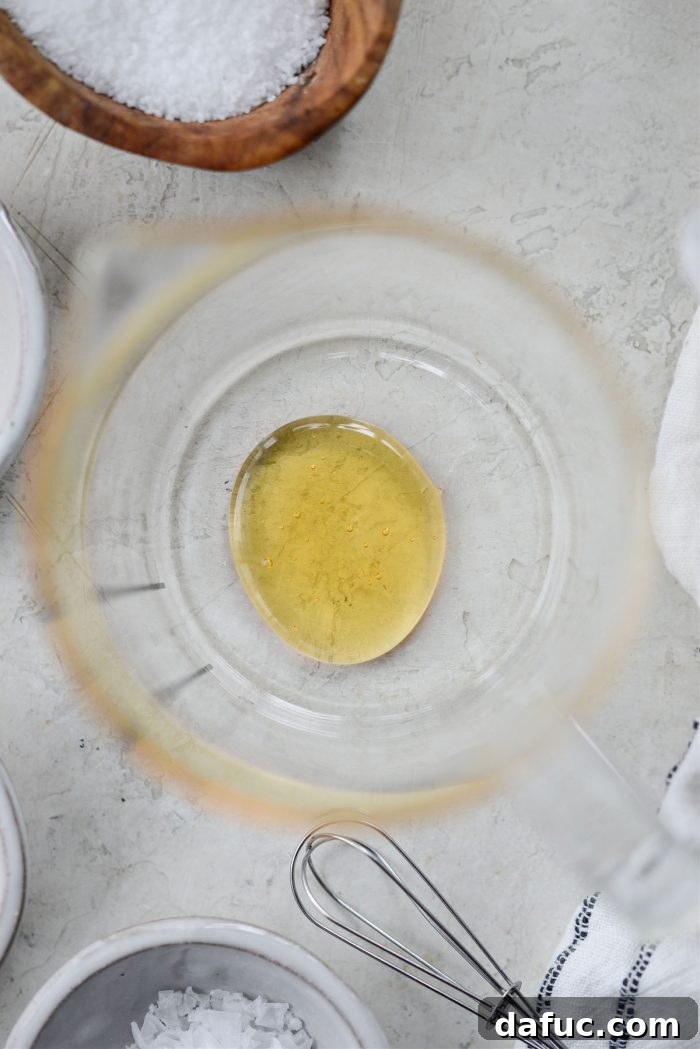 Adding honey to a liquid measuring cup.