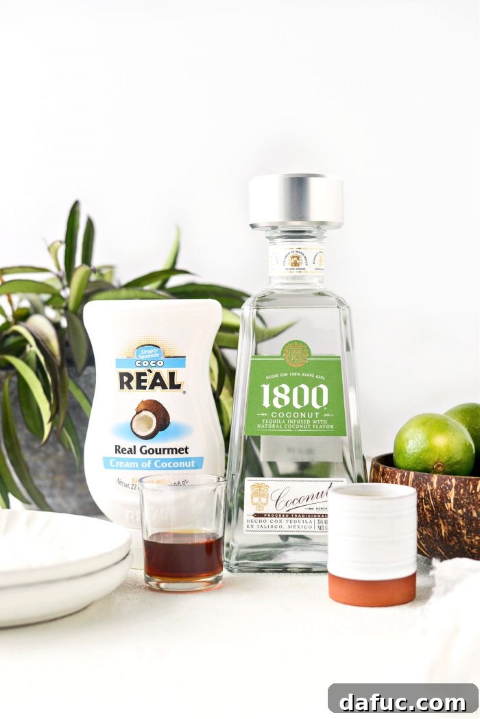 An array of ingredients for a Pina Colada Margarita, including bottles of coconut tequila, cream of coconut, pineapple juice, and fresh limes