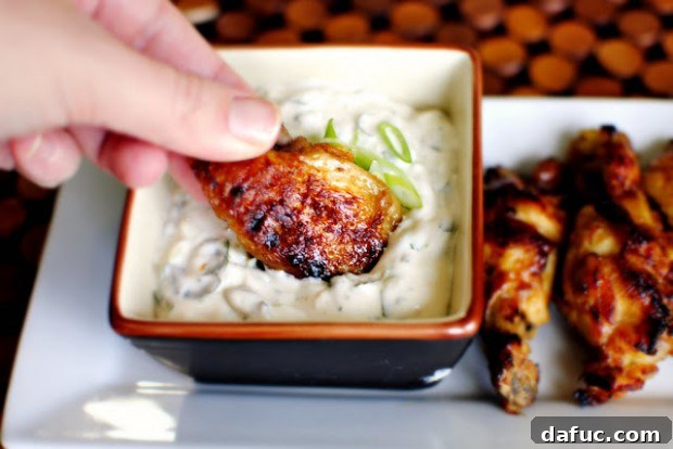 Relishing 2012 A Year of Memories and Morsels 2 A close-up of crispy, perfectly glazed spicy garlic chicken wings, glistening with sauce and artfully arranged on a platter, ready to be devoured with a side of creamy blue cheese dip.