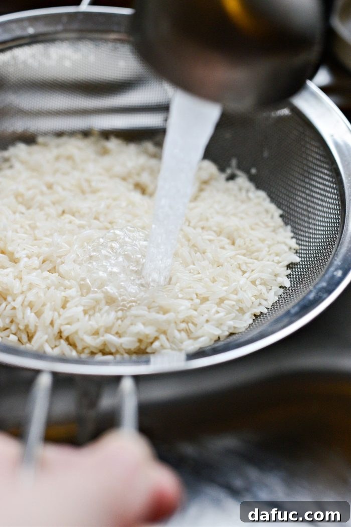 Rinsing white rice thoroughly under cool water