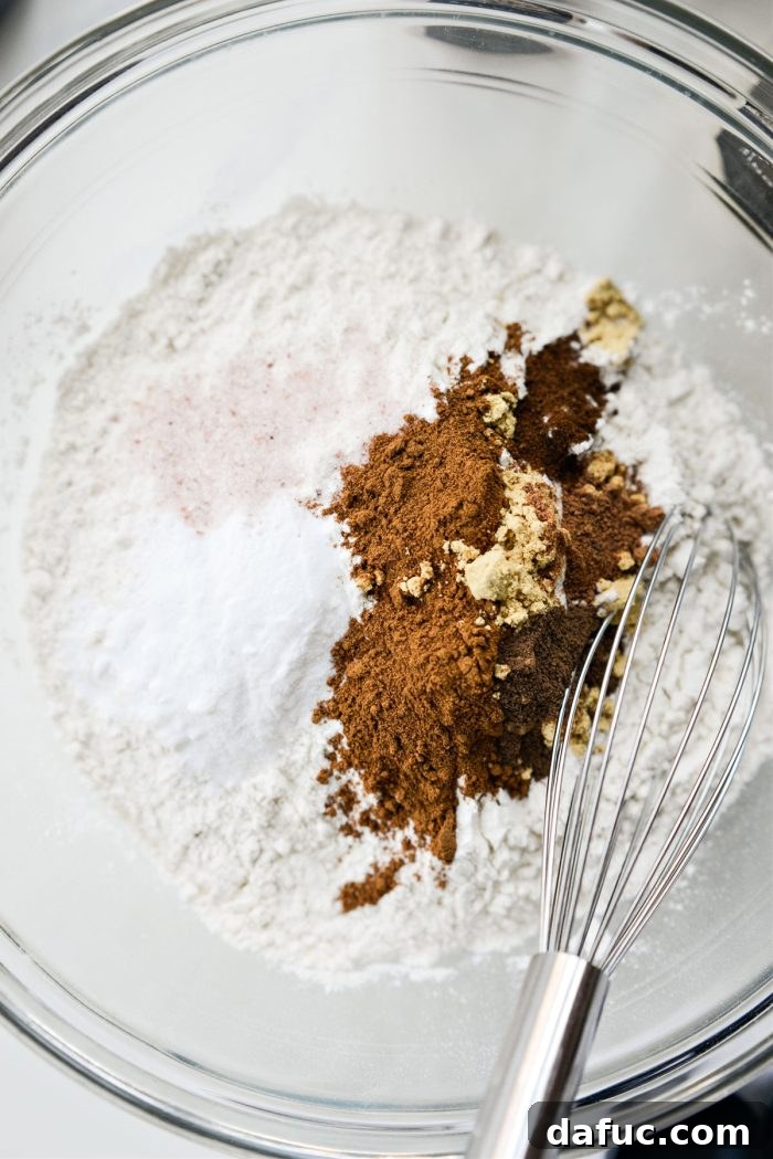 Spiced Pumpkin Molasses Chews 8 A bowl containing precisely measured dry ingredients, including flour and various spices.